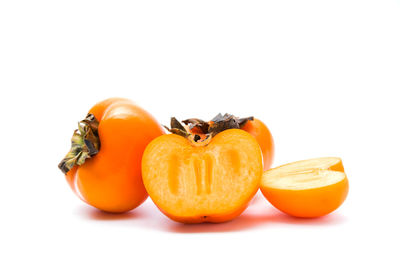 Close-up of orange fruit against white background