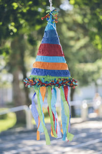 Close-up of colorful decoration hat hanging against trees