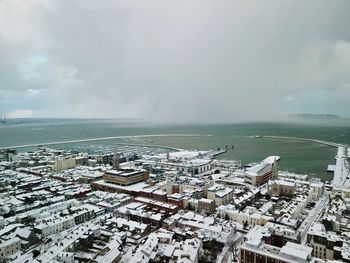 High angle view of buildings by sea against sky