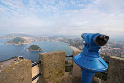 Aerial view of sea and cityscape against sky