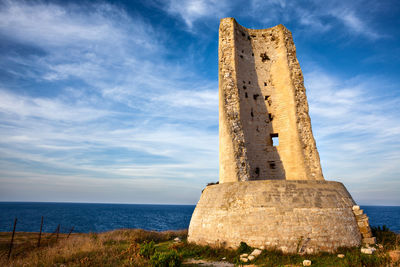 Old ruins by sea against sky