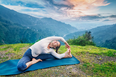 Man relaxing in mountains against sky