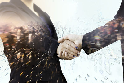 Digital composite image of people shaking hands