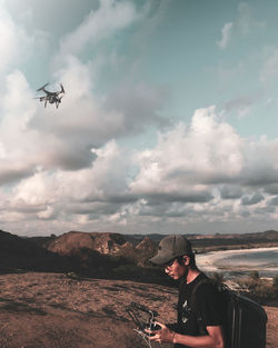 Man flying drone while standing outdoors
