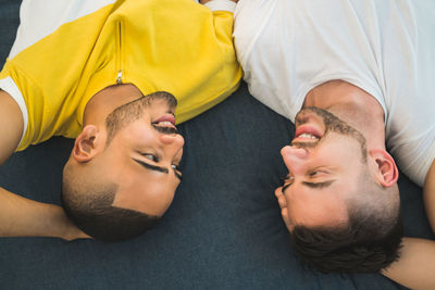 High angle view of gay couple relaxing on bed at home