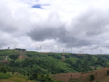 Scenic view of field and trees against cloudy sky