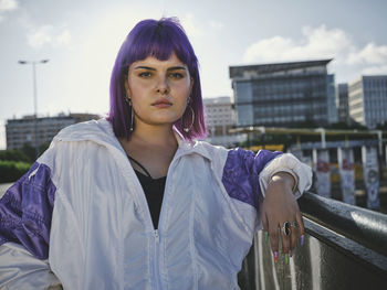 Portrait of beautiful young woman standing against sky