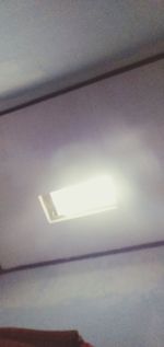 Low angle view of illuminated lamp on ceiling
