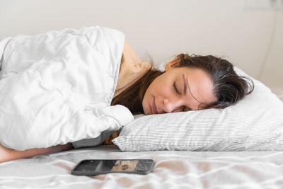 Midsection of woman sleeping on bed