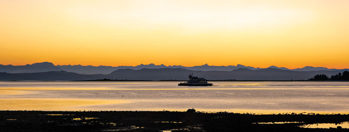 Scenic view of sea against orange sky