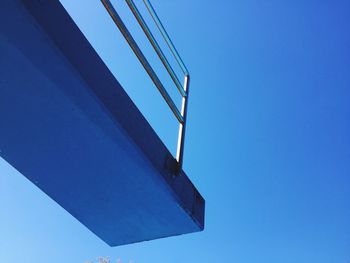 Low angle view of diving platform against clear blue sky