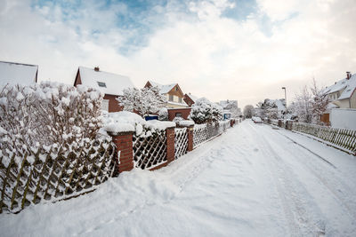 Snow covered houses and buildings against sky