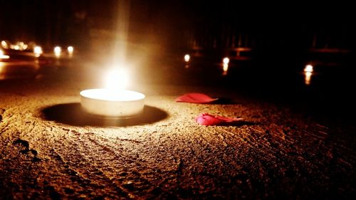 Lit candle in dark room