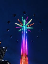 Low angle view of illuminated ferris wheel against sky at night