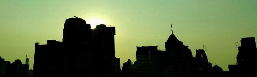 Silhouette buildings against sky during sunset