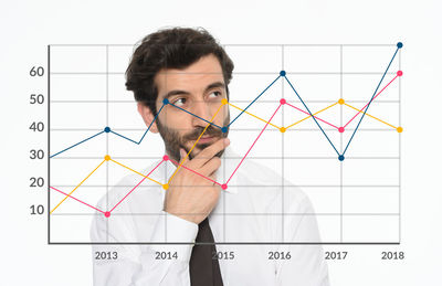 Thoughtful businessman looking at chart in office