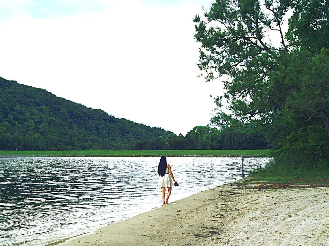 REAR VIEW OF WOMAN STANDING ON BEACH