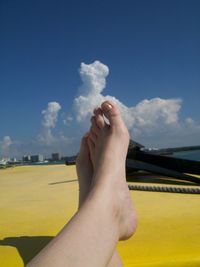 Low section of man legs against blue sky