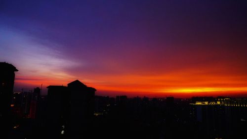 Silhouette buildings against sky during sunset