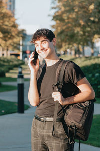 Young man talking on mobile phone while standing outdoors
