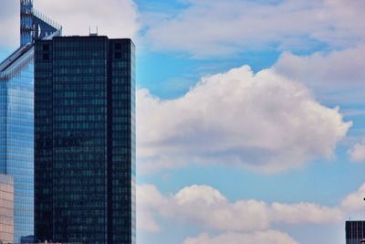 Low angle view of modern building against cloudy sky