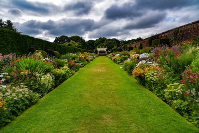 Scenic view of garden against cloudy sky