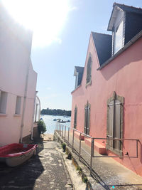 Houses by canal amidst buildings against sky