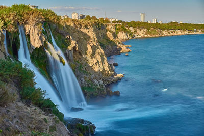 Scenic view of waterfall against sky