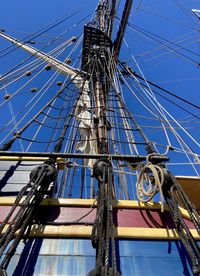 Low angle view of sailboat against blue sky