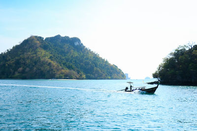 Boat sailing in sea against clear sky