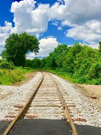 Railroad track amidst trees against sky