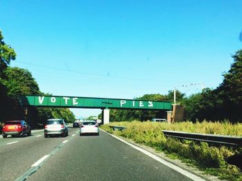 Road sign against clear blue sky