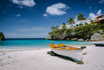 Boat moored on beach against sky