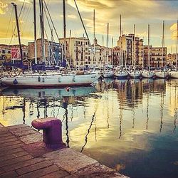 Boats in harbor at sunset