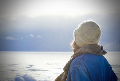 Side view of woman standing b frozen sea