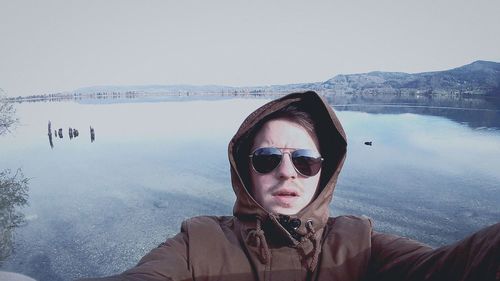 Portrait of young woman in sunglasses against clear sky