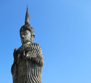 Low angle view of statue against blue sky