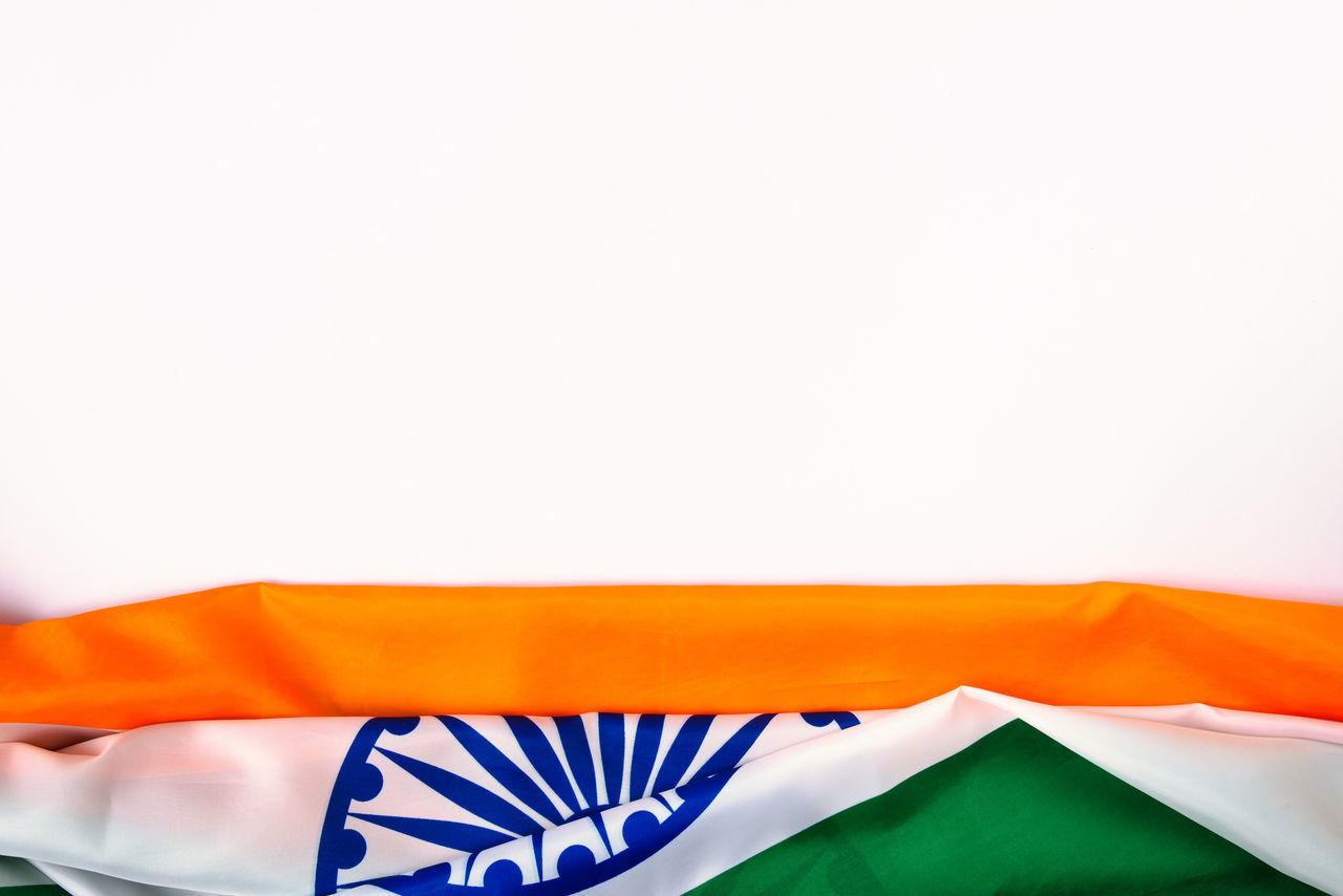 CLOSE-UP OF MULTI COLORED FLAGS ON WHITE BACKGROUND