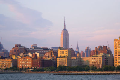 Buildings in city against cloudy sky