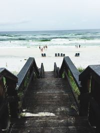 Steps leading towards beach against sky