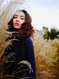 Portrait of beautiful woman on field against sky