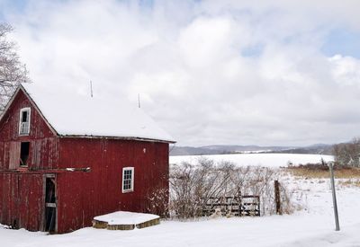 House on field against sky during winter