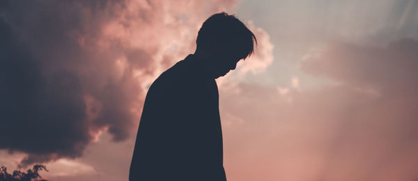 Silhouette man standing against sky during sunset