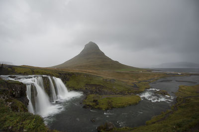 Scenic view of waterfall against sky