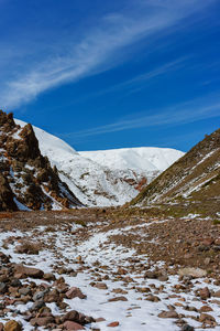 Scenic view of snowcapped mountains against blue sky