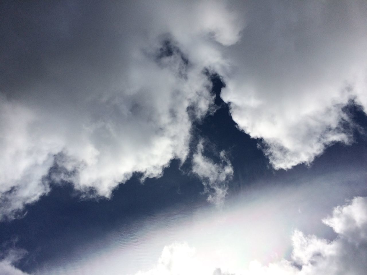 LOW ANGLE VIEW OF SUNLIGHT STREAMING THROUGH CLOUDS AGAINST SKY