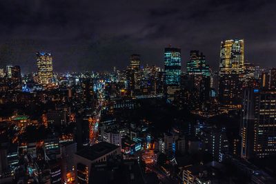 Illuminated cityscape against sky at night