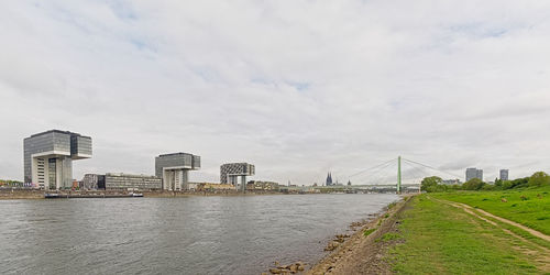 Bridge over river in city against sky