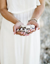 Midsection of bride holding wedding dress