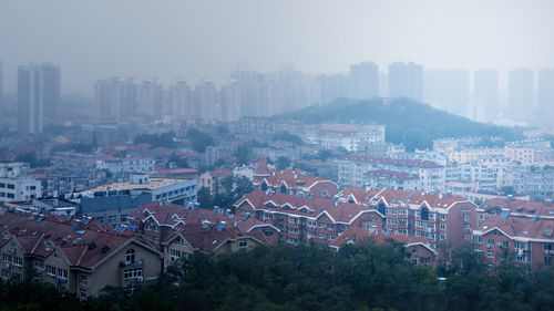 High angle view of houses in town against sky